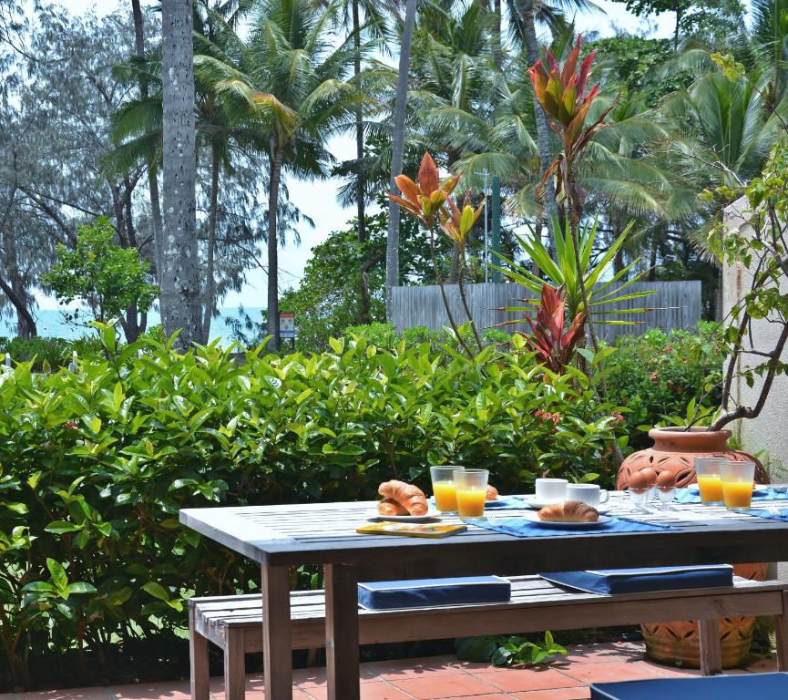 a table with food and glasses of orange juice at Number 2 On The Beach | Beautiful Beachfront Villa in Port Douglas