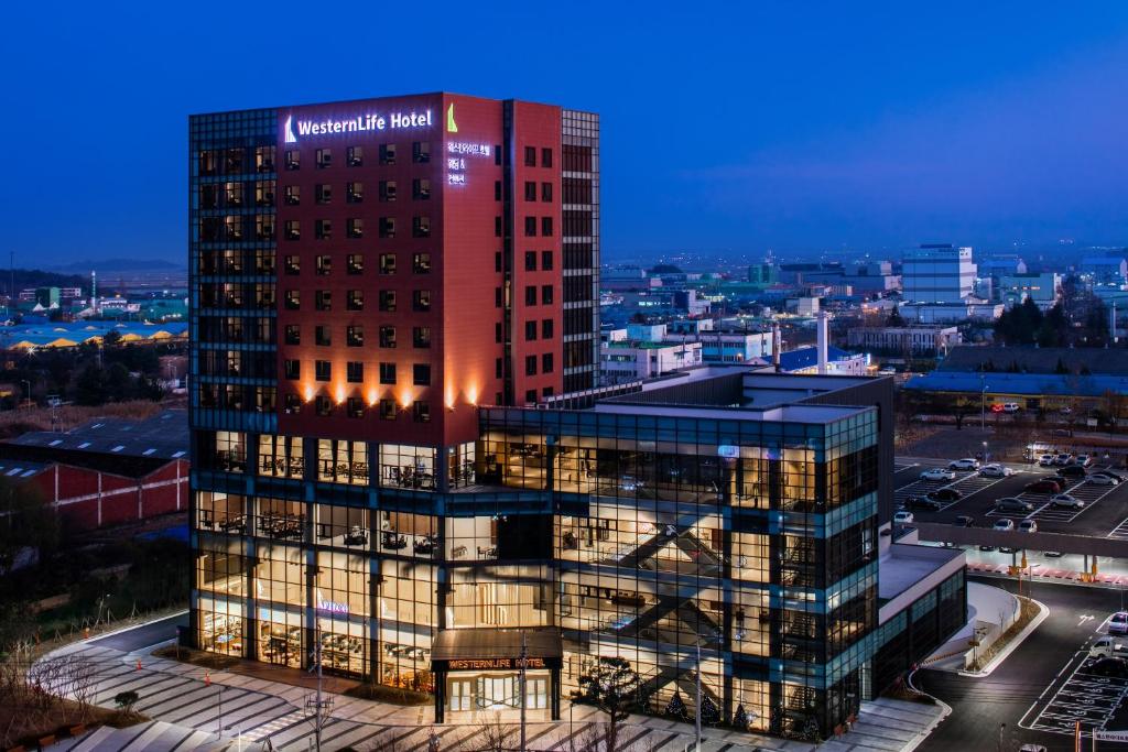 a rendering of a tall office building at night at WesternLife Hotel in Iksan