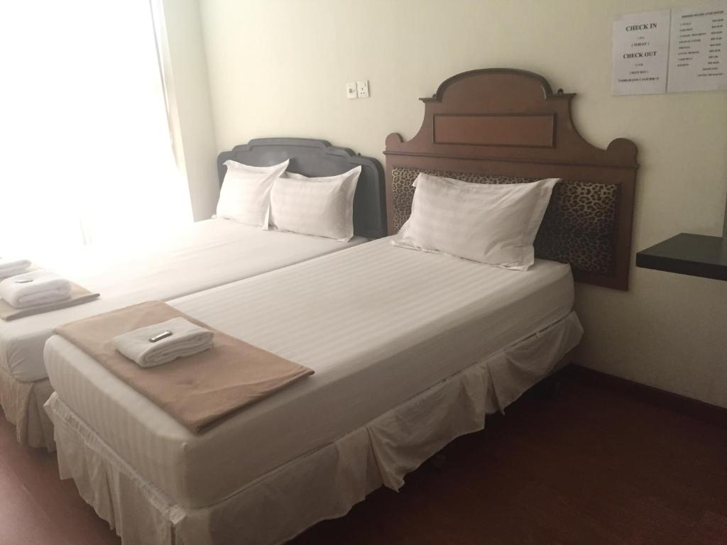 2 łóżka pojedyncze w pokoju hotelowym z: w obiekcie Hotel Sri Malim Sungkai w mieście Sungkai
