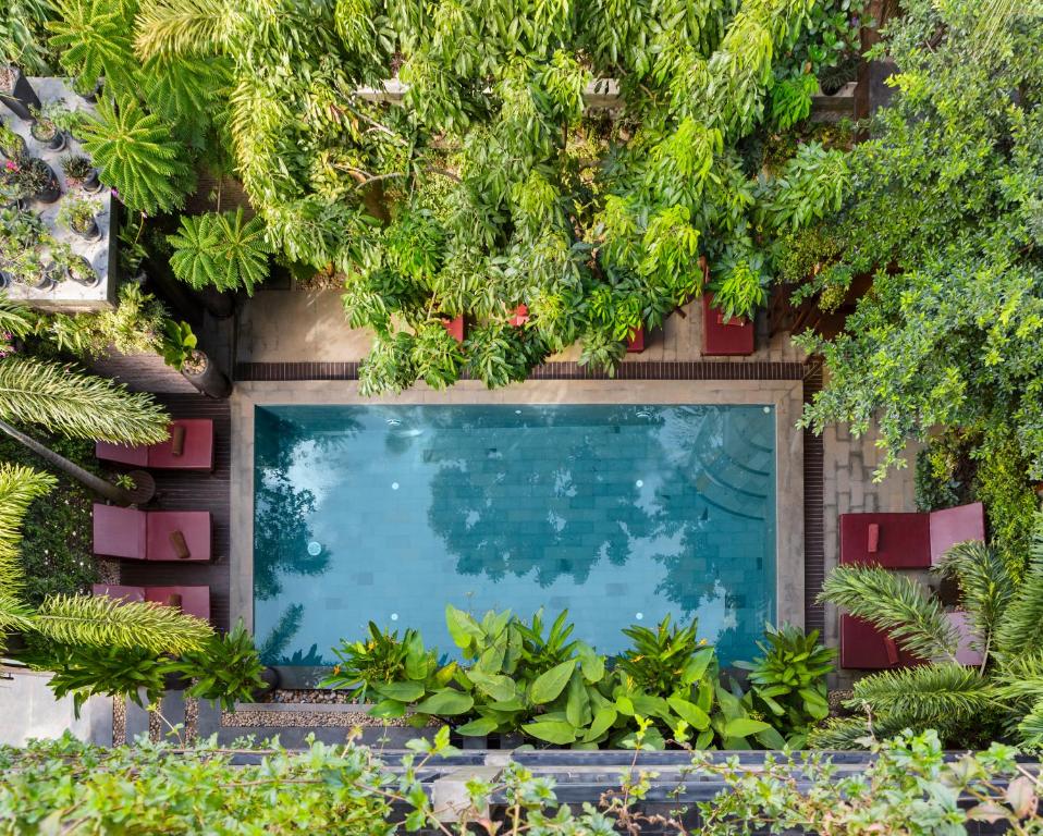 une piscine entourée d'arbres et de plantes dans l'établissement Won Residence & Spa, à Siem Reap