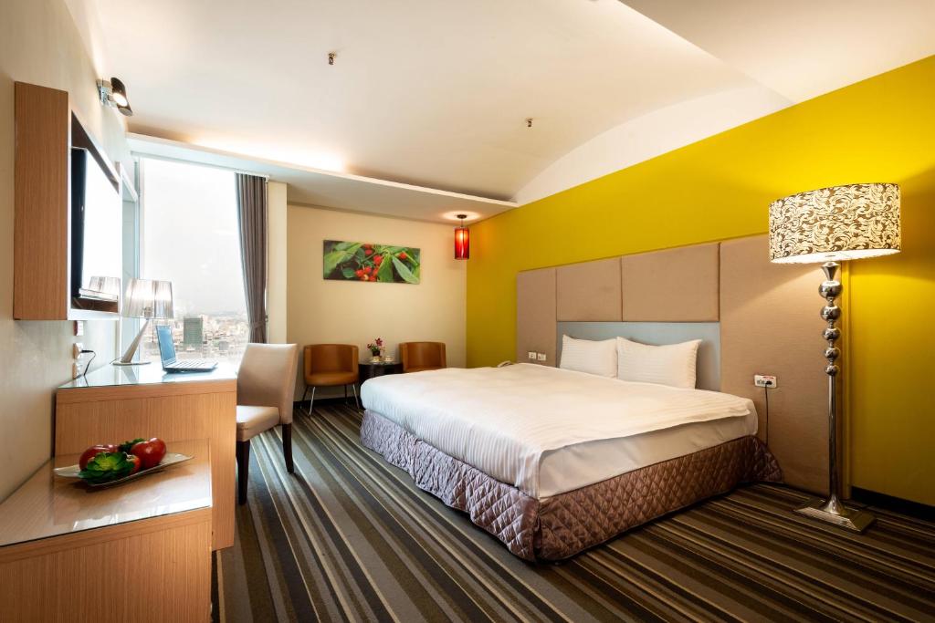 a hotel room with a bed and a desk at Yoyo Hotel in Chiayi City