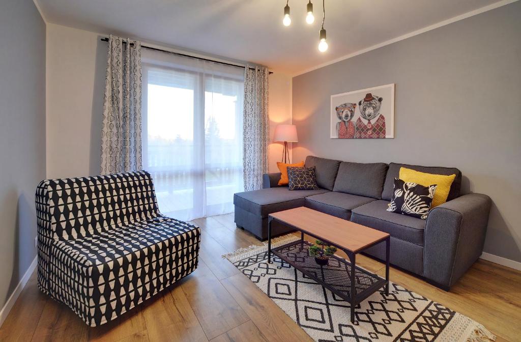 uma sala de estar com um sofá e uma mesa em Apartamenty Sun Seasons 24 - Żeromskiego em Szklarska Poręba