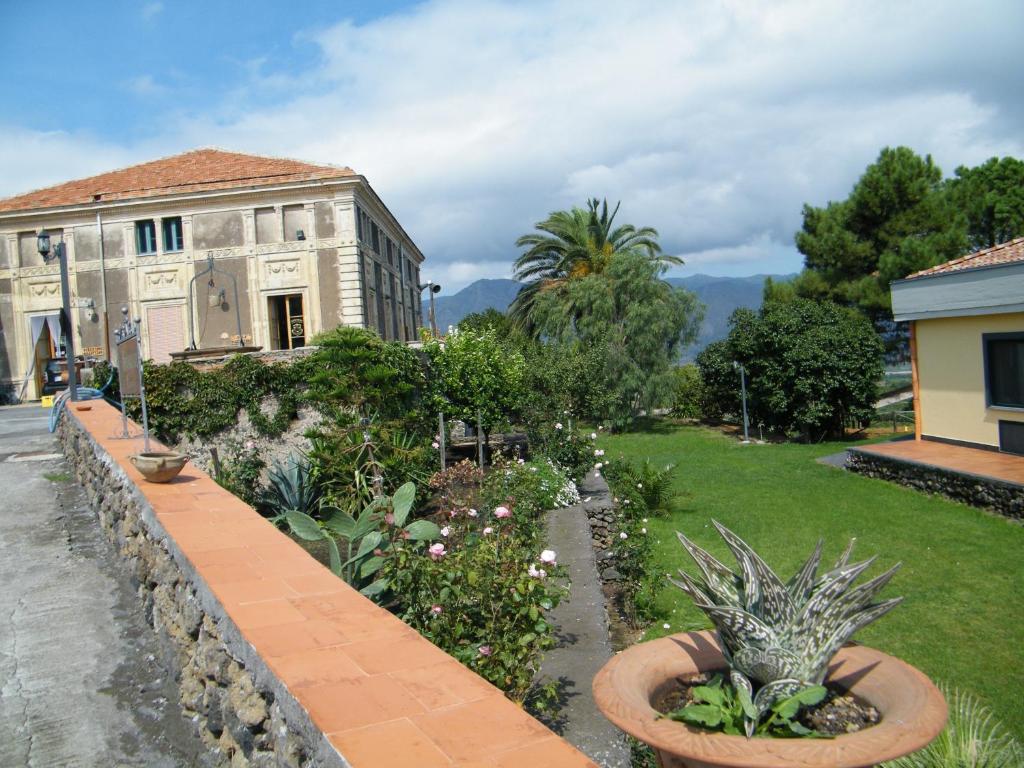 un jardín con plantas frente a un edificio en Etna Wine Azienda Agrituristica, en Passopisciaro
