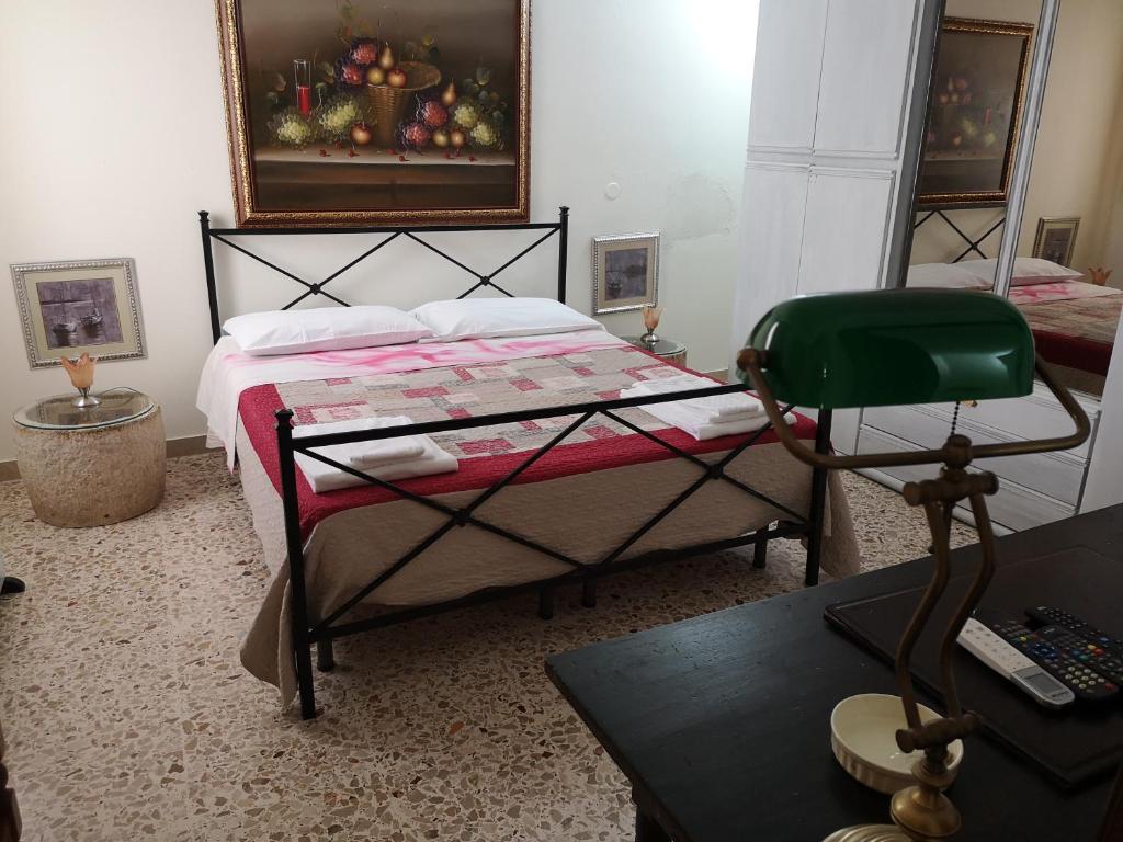 a bedroom with a bed with a green chair at Home Egitto 53 in Modica