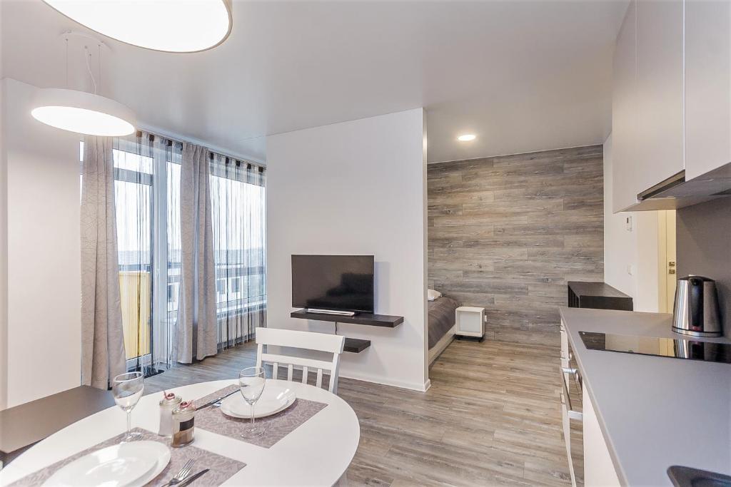 a kitchen and living room with a table and a television at Apartments Vilnius 1 near center with a roof terrace and parking in Vilnius
