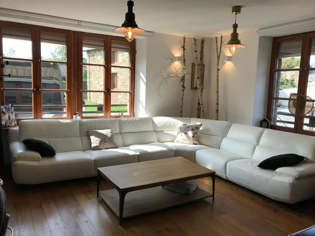 a living room with a white couch and a coffee table at La chouette au bouleau in Hargnies