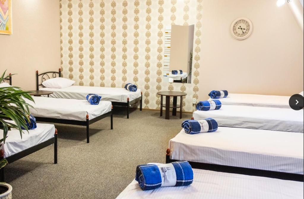 a room with four beds with blue and white sheets at hostel Koleso in Odesa