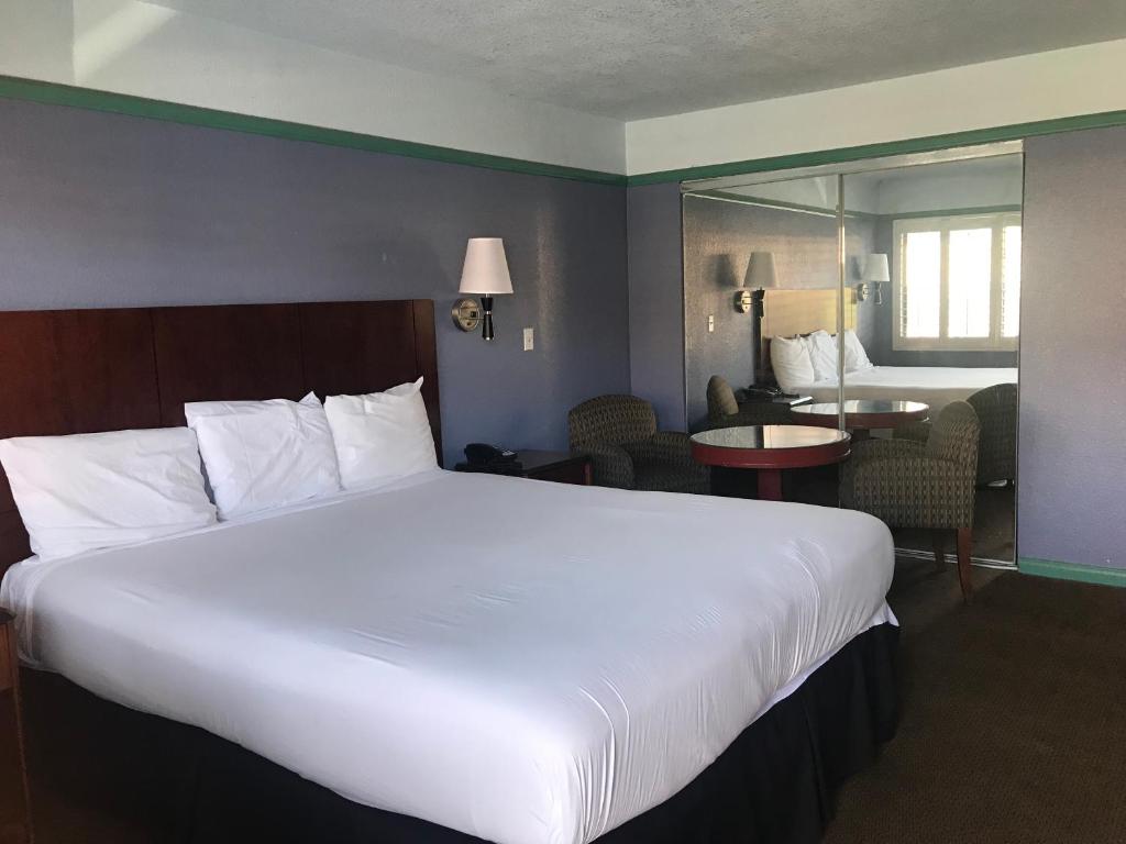 ein großes weißes Bett in einem Hotelzimmer in der Unterkunft Big A Motel in Orange