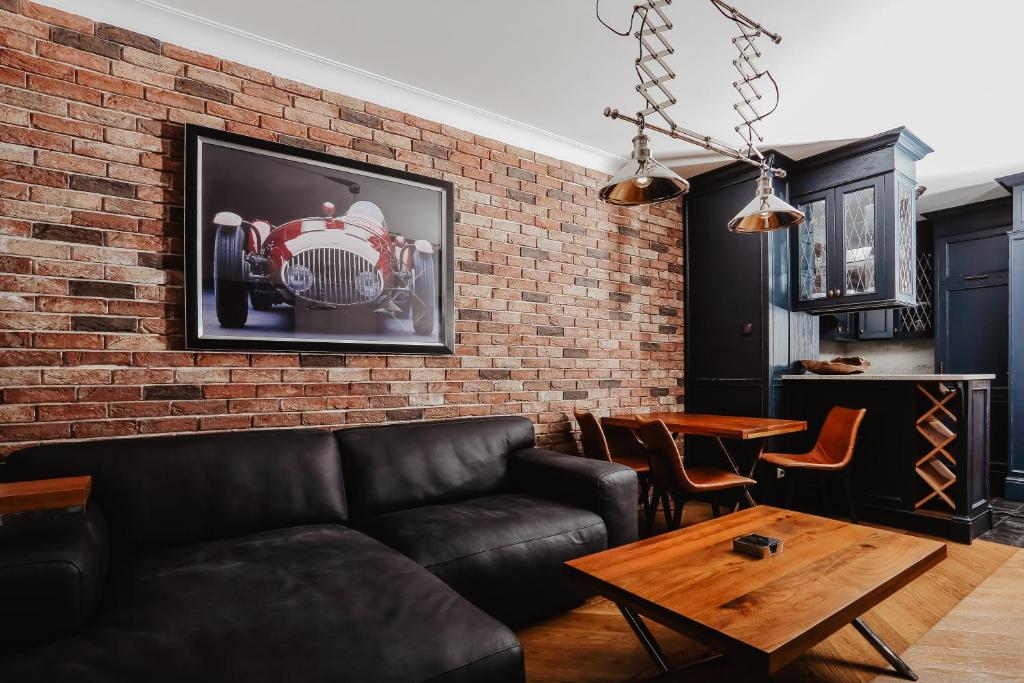 a living room with a couch and a brick wall at Apartament Indygo in Łomża