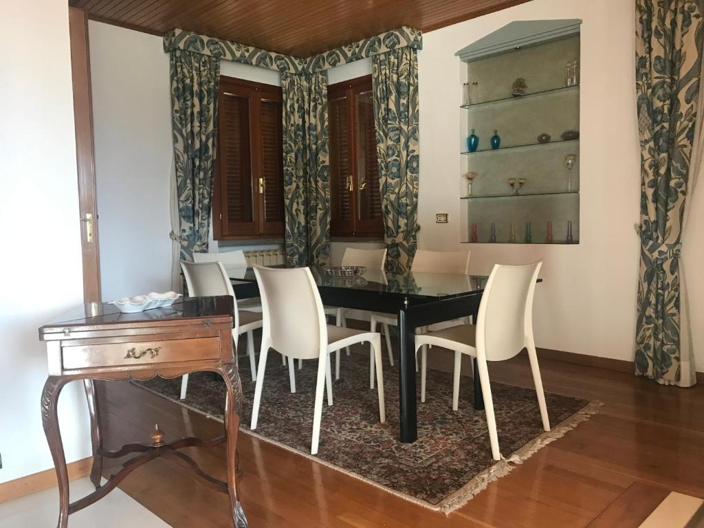 une salle à manger avec une table noire et des chaises blanches dans l'établissement Casa Alberto dalla Roby, à Castel di Sangro