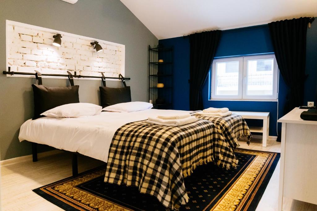 a bedroom with a bed with a checkered blanket on it at Beautiful best location apartment "Blue Mouse" in Plovdiv