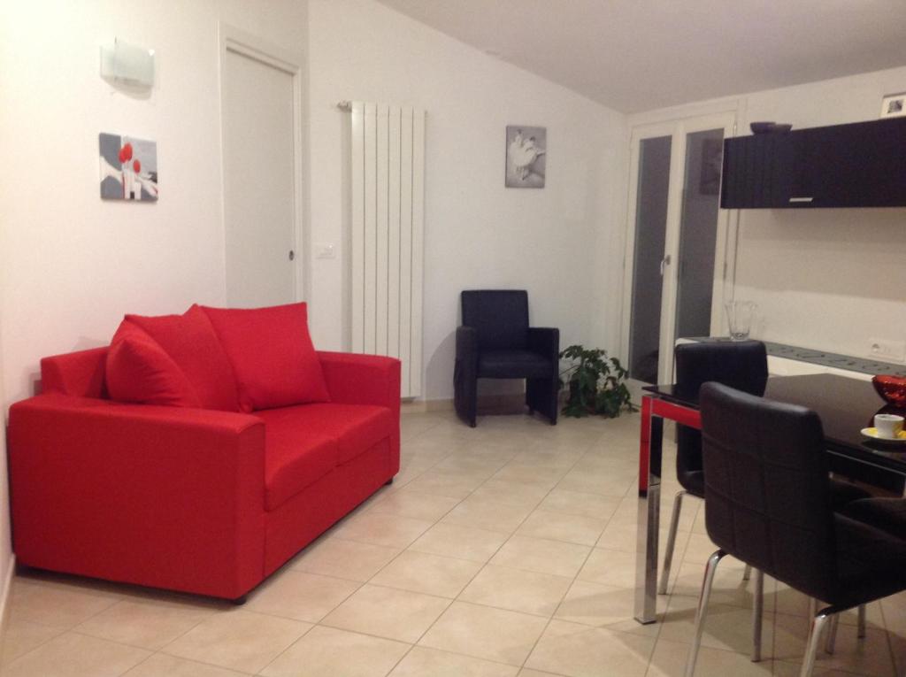 un soggiorno con divano rosso e tavolo di Appartamenti la Castagna ad Abbadia San Salvatore