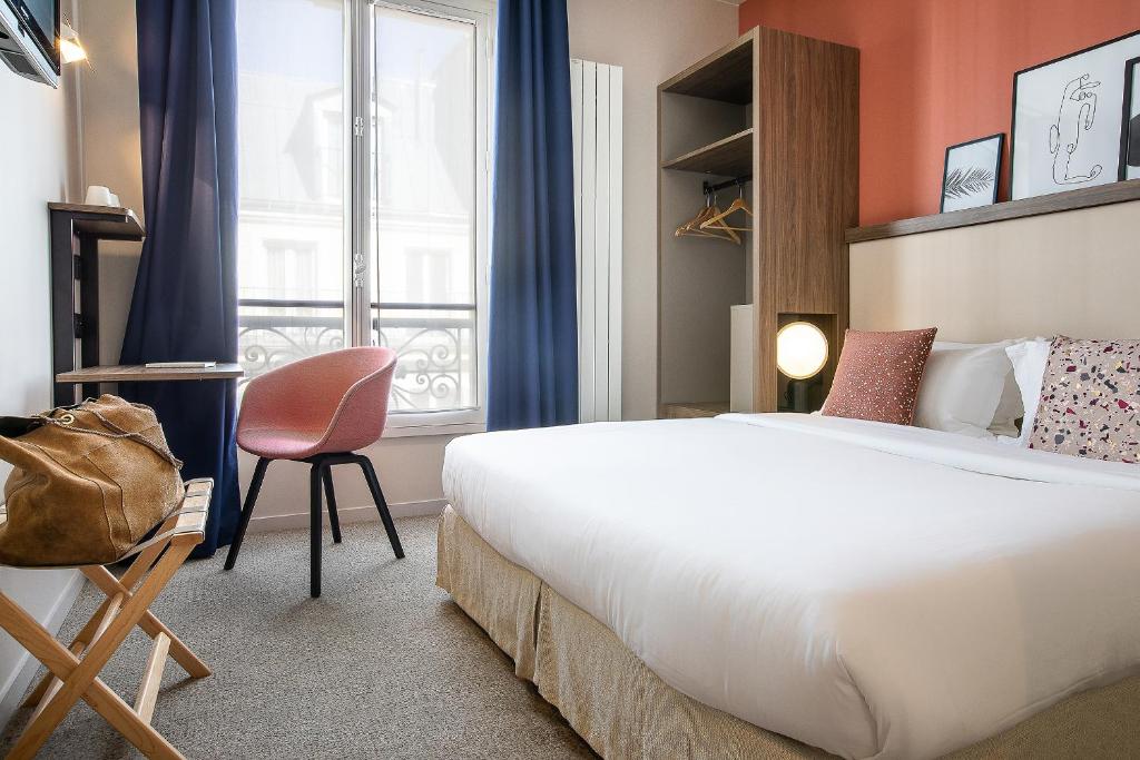 a hotel room with a bed and a chair and a window at Le Petit Belloy in Paris