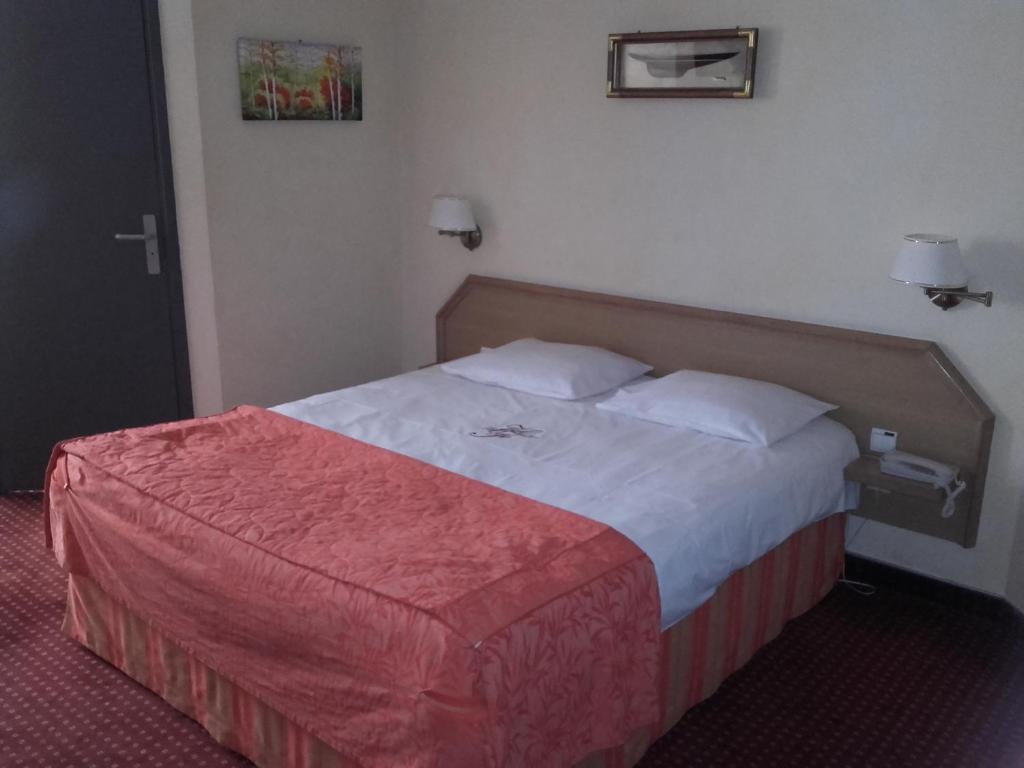 Een bed of bedden in een kamer bij H&ocirc;tel Foch