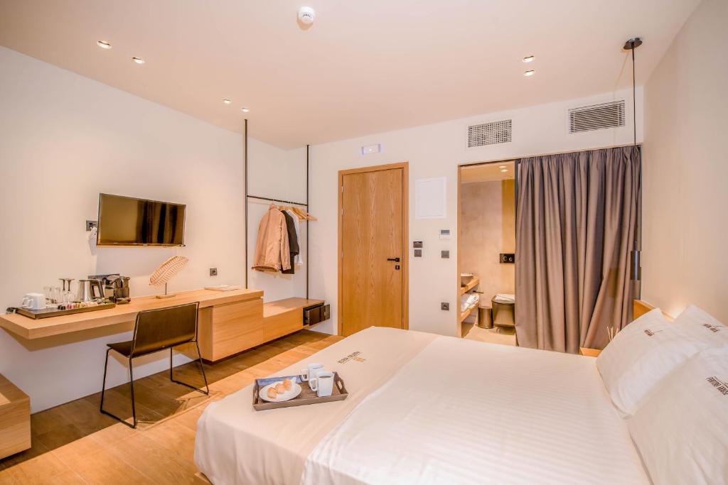 a hotel room with a white bed and a desk at Portou House in Chania