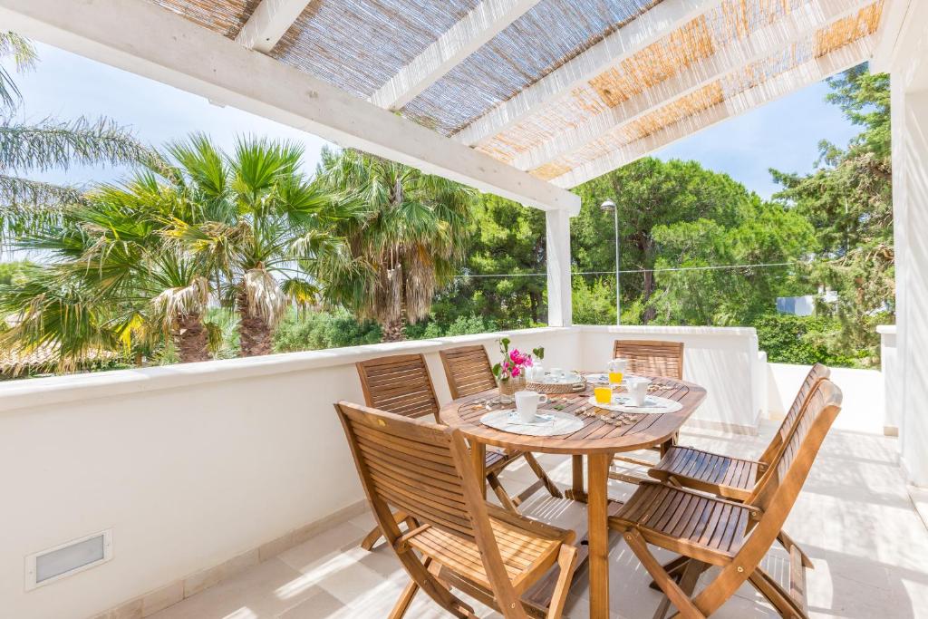 a patio with a table and chairs on a balcony at Casa Bianca in Salento in Torre Santa Sabina