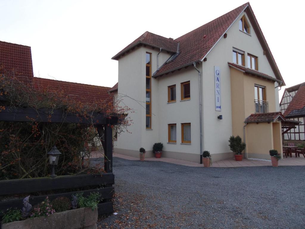un gran edificio blanco con una puerta delante en Restaurant - Garni bei Peppo en Ebern
