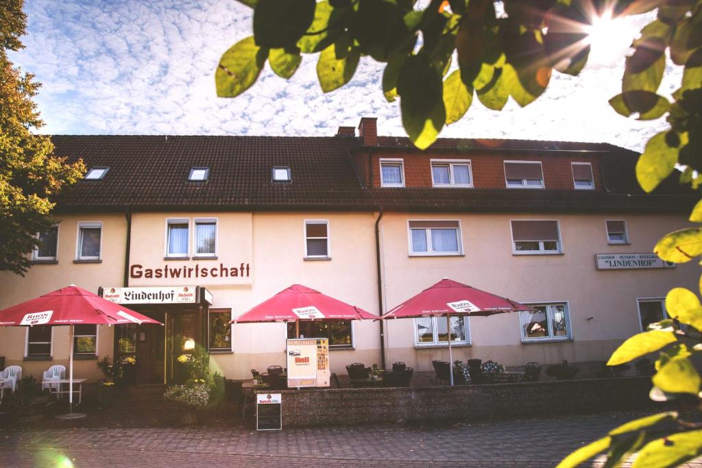 a hotel with red umbrellas in front of it at Lindenhof Keulos in Künzell