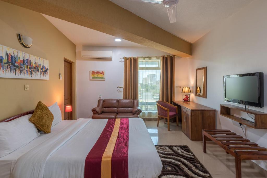 pokój hotelowy z łóżkiem i telewizorem w obiekcie Hotel Raha Tower w mieście Dar es Salaam