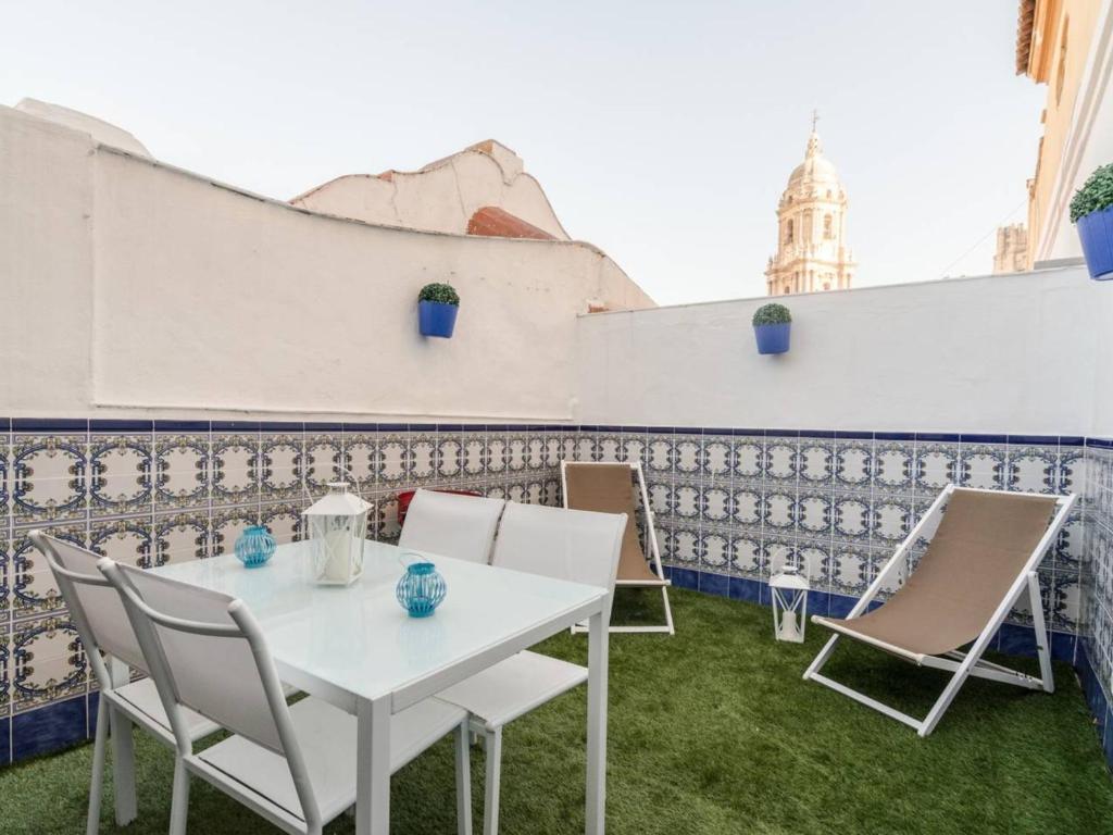 a white table and chairs on a patio with a building at Larios penthouse with terrace and 2 bedrooms in Málaga