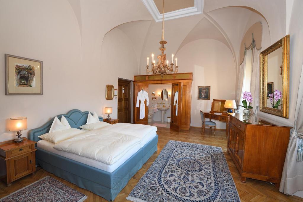 a bedroom with a bed and a desk and a mirror at Hotel Schloss Dürnstein in Dürnstein