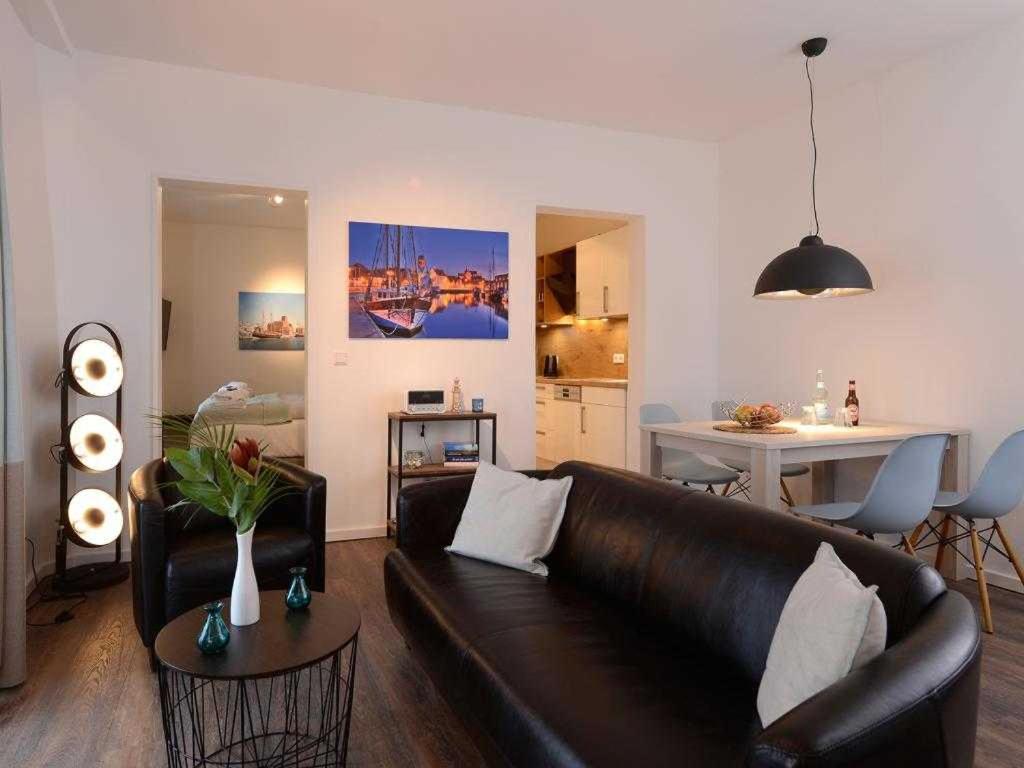 uma sala de estar com um sofá de couro castanho e uma mesa em Ohlerich Speicher App_ 19 em Wismar