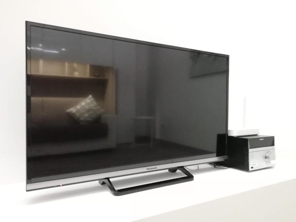 TV de pantalla plana grande sentada en una mesa en Indipendent Luxury Mini Apartment en Pescara