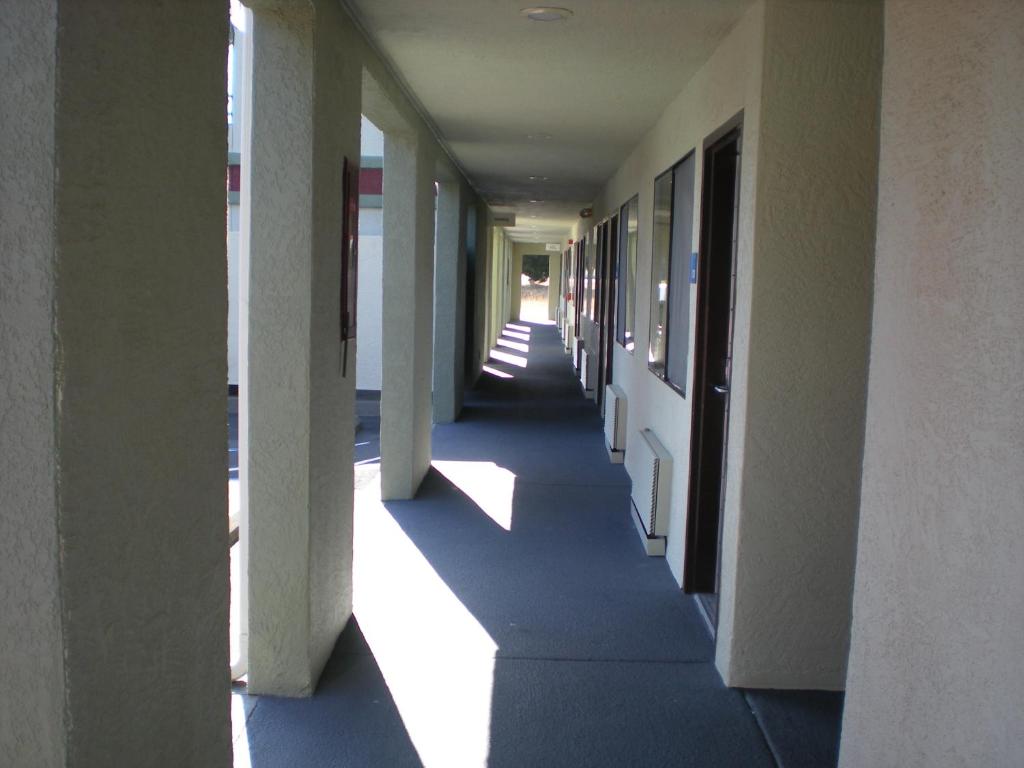 an empty hallway of a building with the sun shining down at The Redwood Riverwalk, a boutique hotel in Fortuna