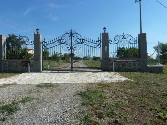 un cancello in un campo con aphalt di Il CASALE NELLA TUSCIA. BIOFARM. Casa nel Giardino a Viterbo