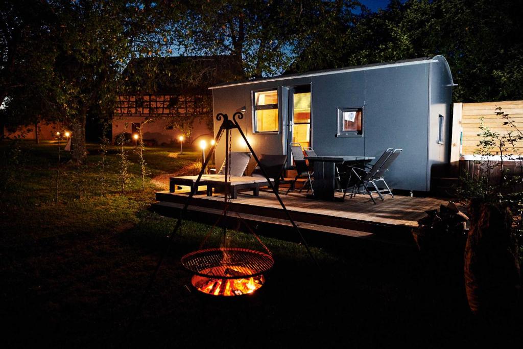 a tiny house with a fire in the yard at Schäferwagen Merino in Gräfenberg