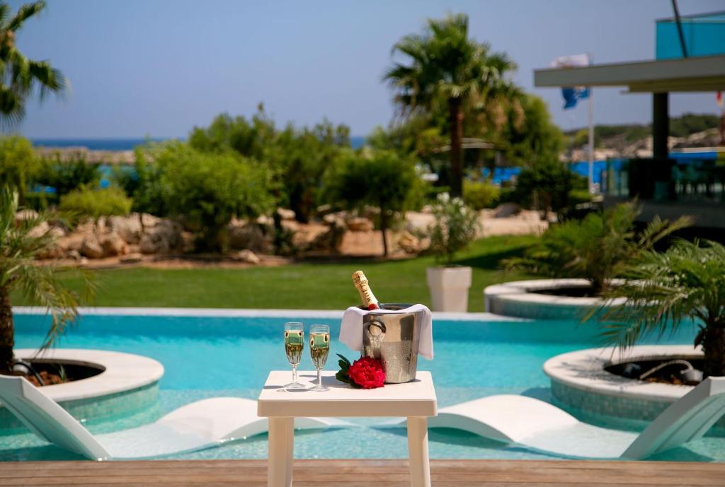 a table with two glasses of wine and a napkin at Asterias Beach Hotel in Ayia Napa
