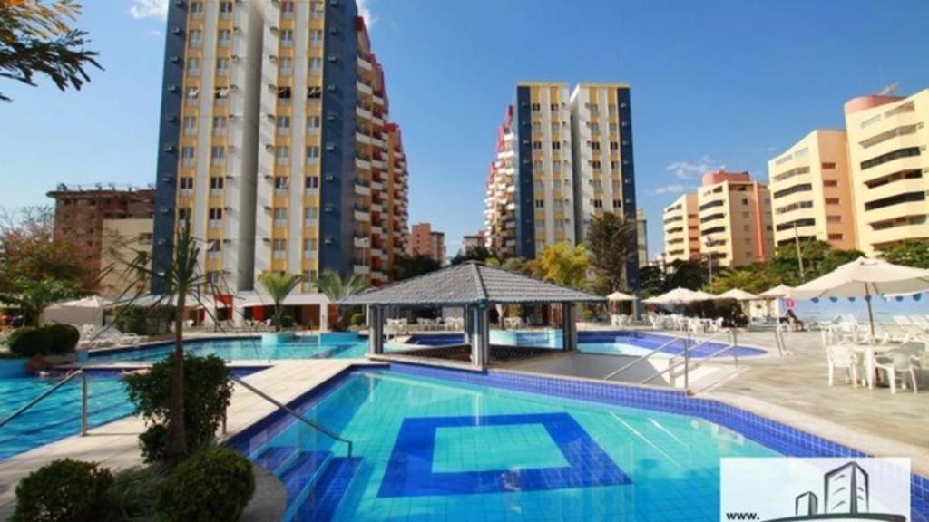 a large swimming pool in a city with tall buildings at Eldorado Park Caldas Novas in Caldas Novas