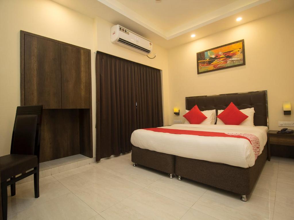 a bedroom with a large bed with red pillows at Hotel Mount View, Siliguri in Siliguri