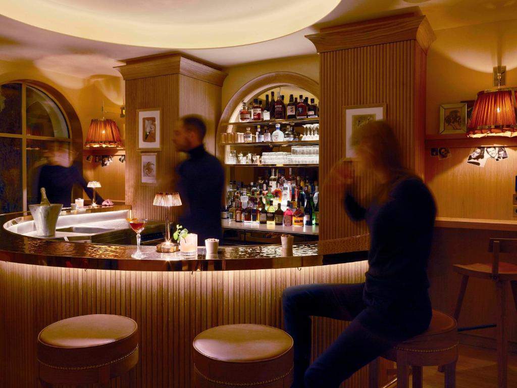 a woman sitting at a bar in a restaurant at 9Confidentiel in Paris