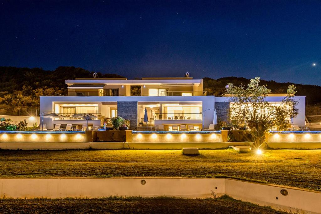 a large house with lights in front of it at night at Afisia Villas in Sarti