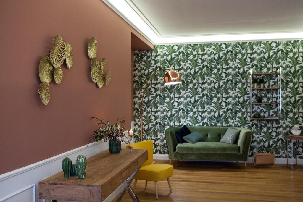 Dimora Molise في Vinchiaturo: غرفة معيشة مع أريكة خضراء وكراسي صفراء