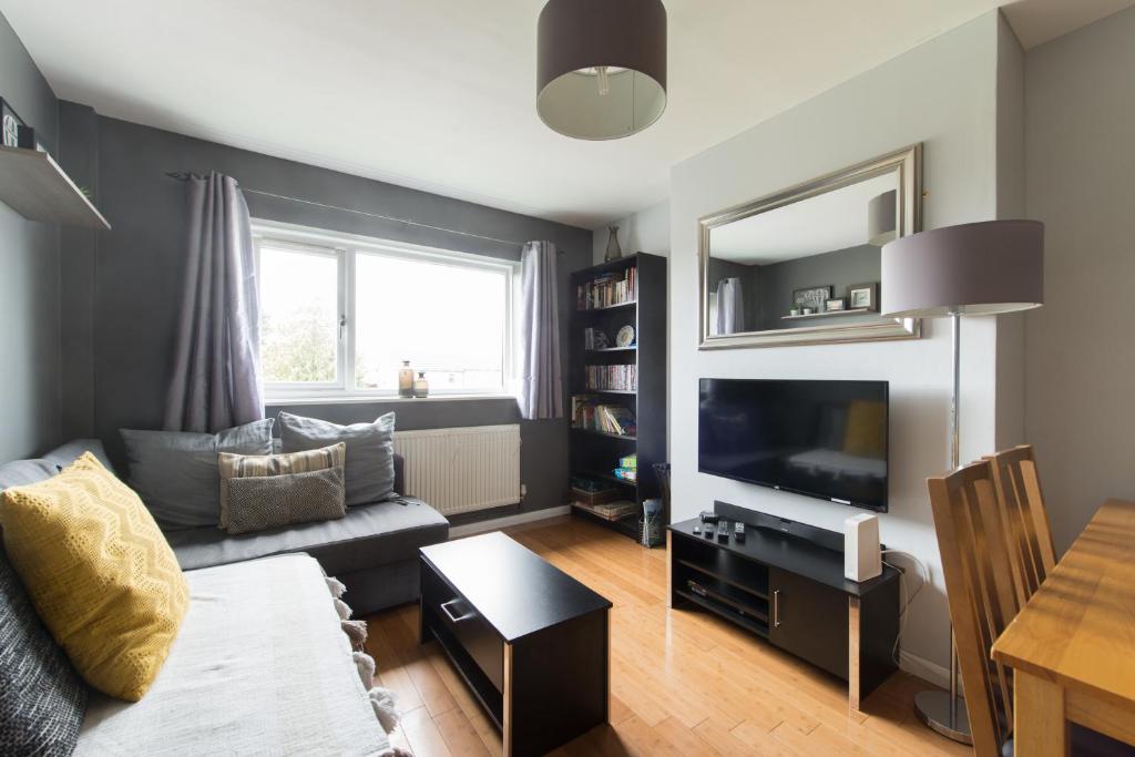 a living room with a couch and a television at Chesterton Court Apartment in Gloucester