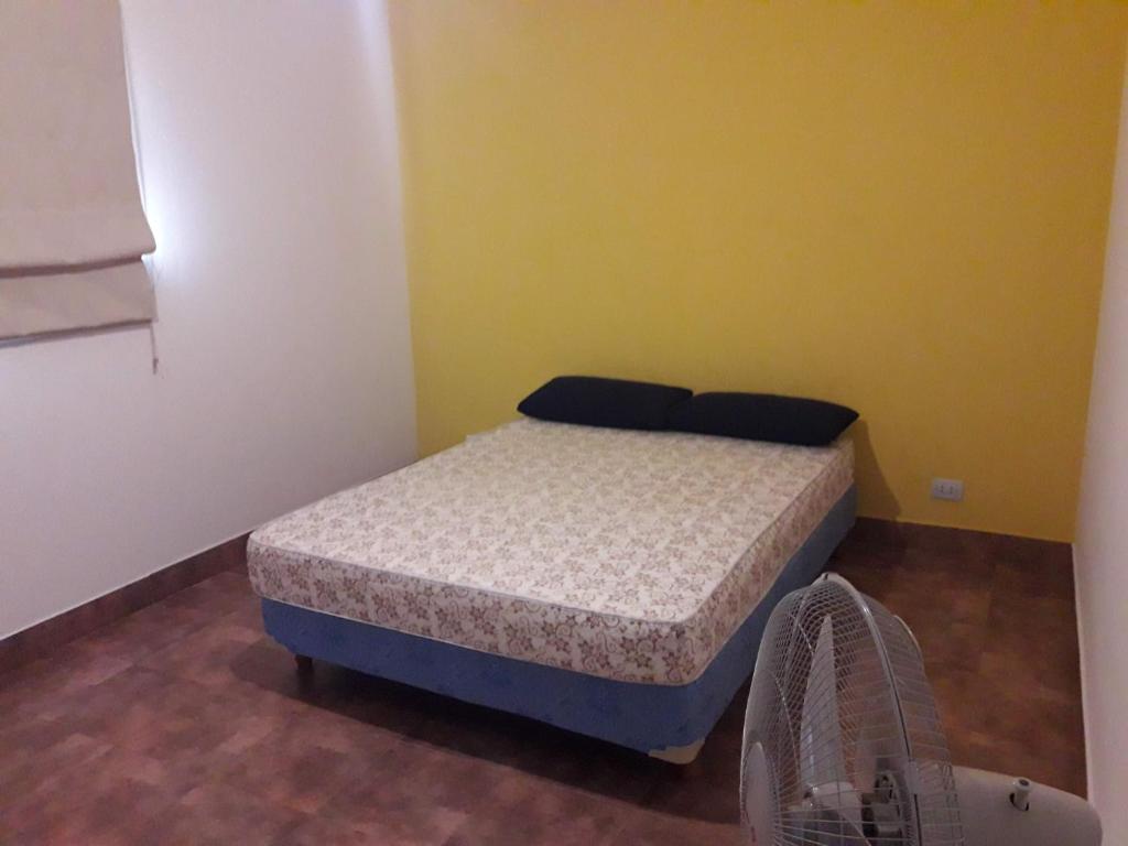 a small bedroom with a bed and a fan at Departamento Estancia Vieja 74 PB in Estancia Vieja