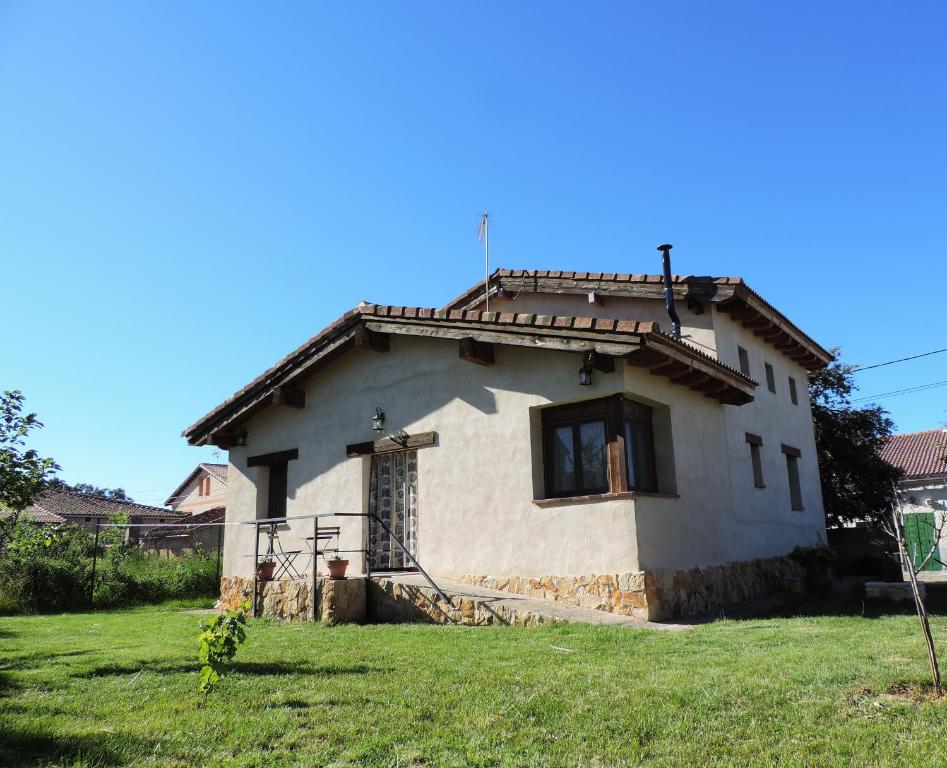 una pequeña casa blanca con una ventana en un campo en La Casa del Cartero Pablo en Saldaña de Ayllón