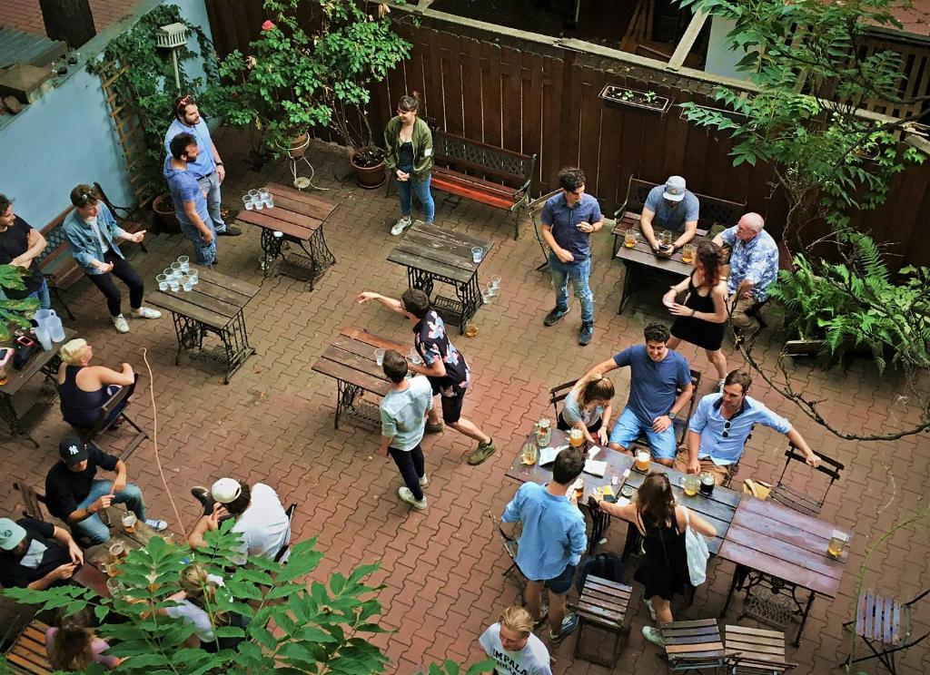 un grupo de personas de pie alrededor en un patio en Sir Toby's Hostel, en Praga