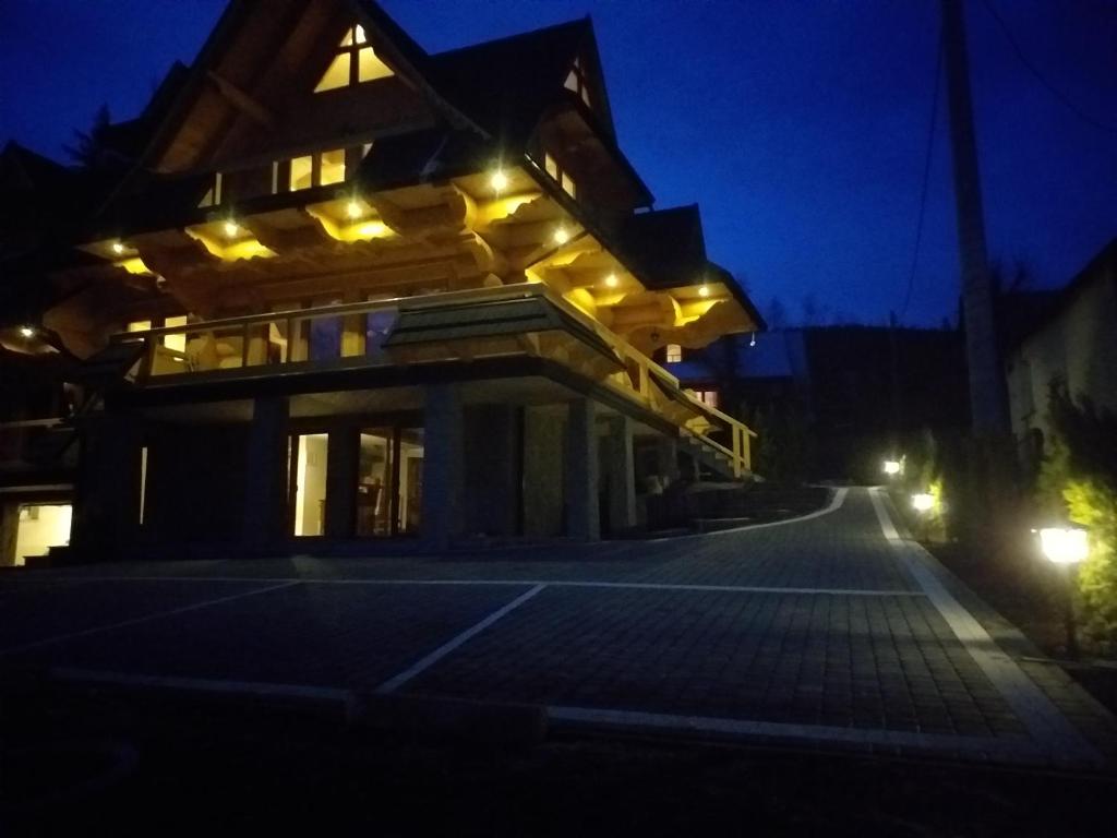 a house lit up at night with lights on it at Willa Górskie Tarasy in Kościelisko