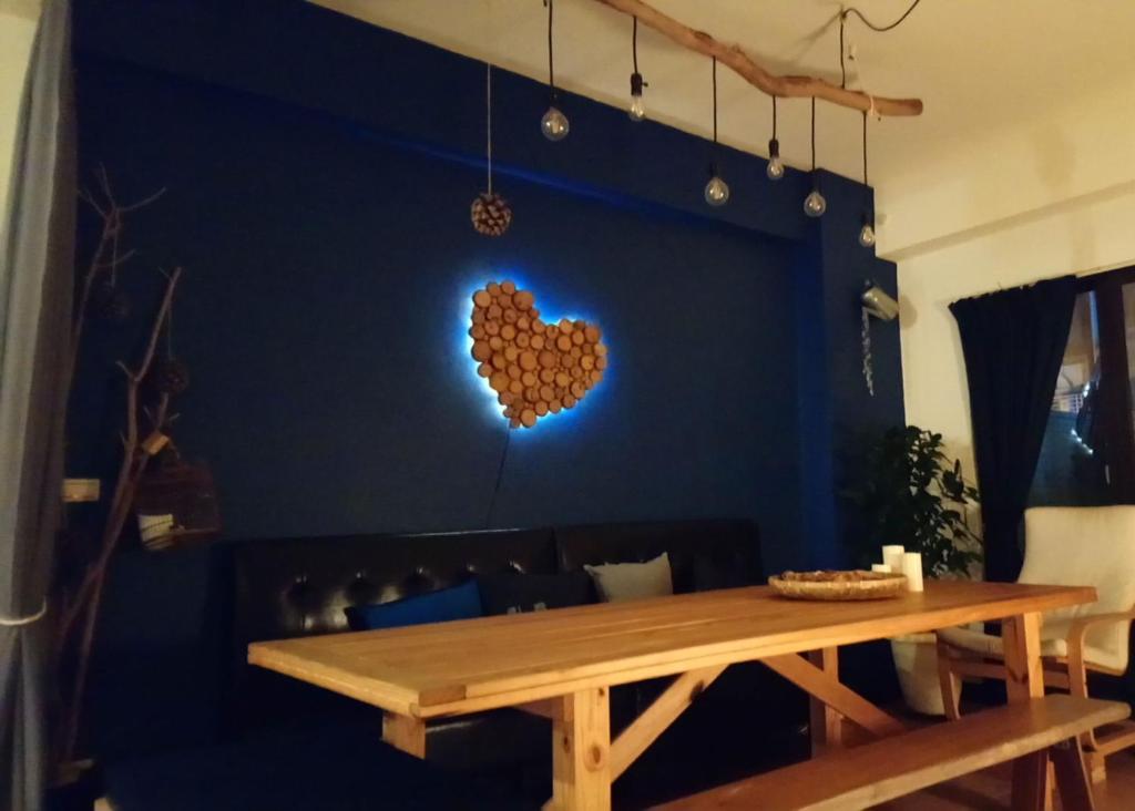 un tavolo in legno in una stanza con un cuore sul muro di Woods Decor - Anping ad Anping