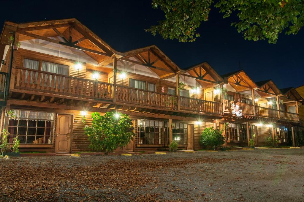 una cabaña de madera con luces por la noche en Apart Hotel Blumenau, en Osorno