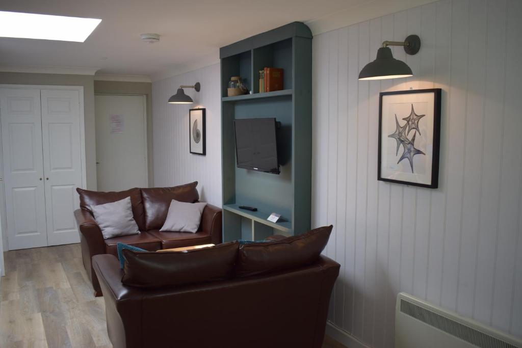 a living room with a couch and a tv at Newlands Holidays in Bridport