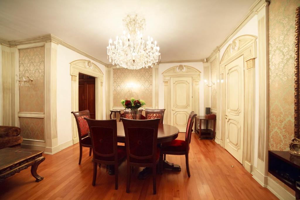 キーウにあるKiev Lypki Luxury Apartmentsのダイニングルーム(テーブル、椅子、シャンデリア付)