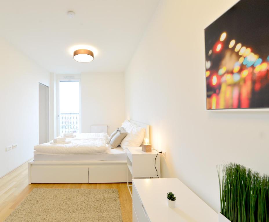 a white bedroom with a bed and a couch at Self-Check-In With View & Free Parking in Vienna