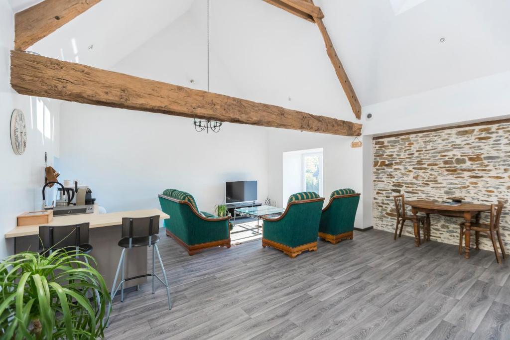 a living room with green chairs and a table at Les Colombes de la Baie du Mont Saint-Michel in Aucey-la-Plaine