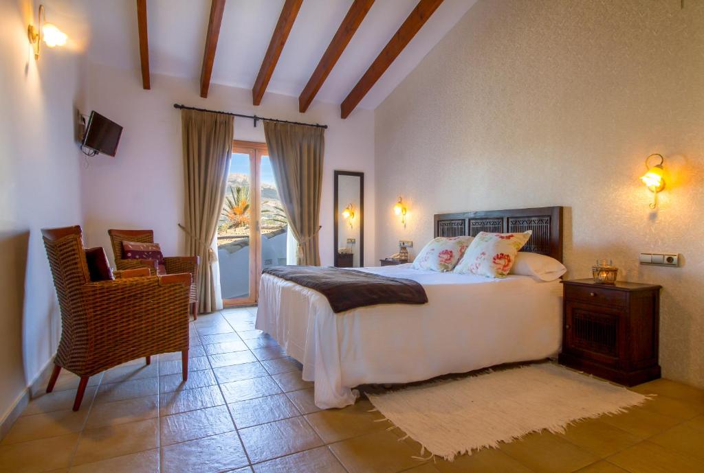 a bedroom with a bed and a table and a chair at Hotel Tossal d'Altea in Altea