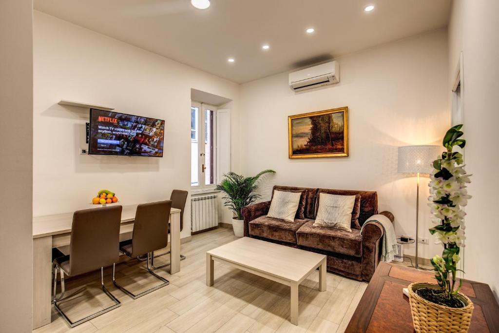 uma sala de estar com um sofá e uma mesa em Fresh House Borghese em Roma