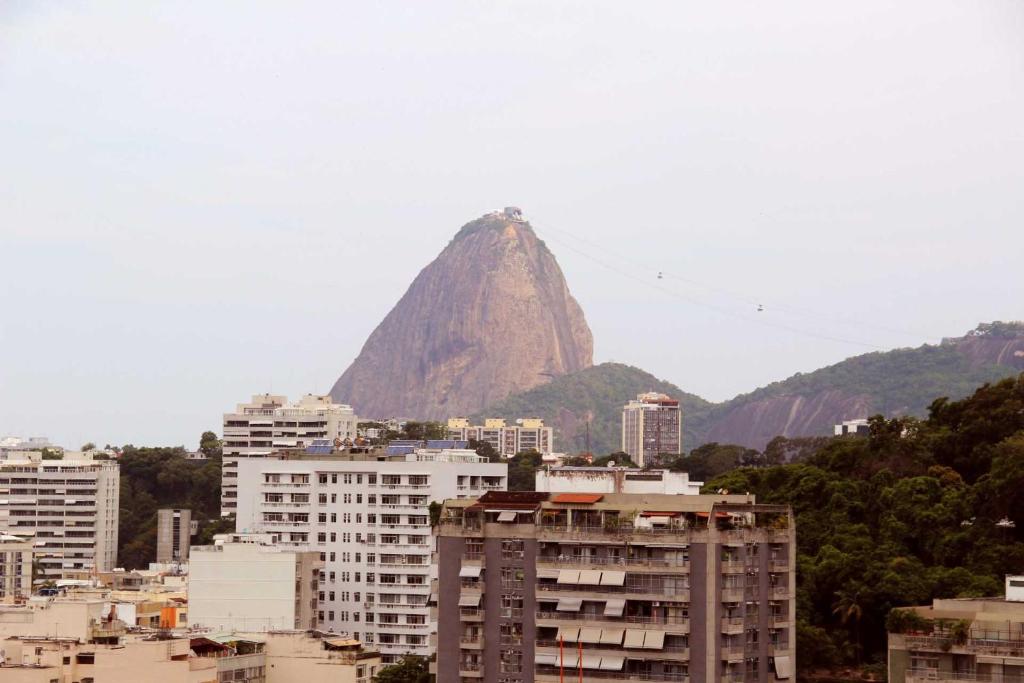 una montaña en el fondo de una ciudad con edificios en Estúdio Laranjeiras, en Río de Janeiro